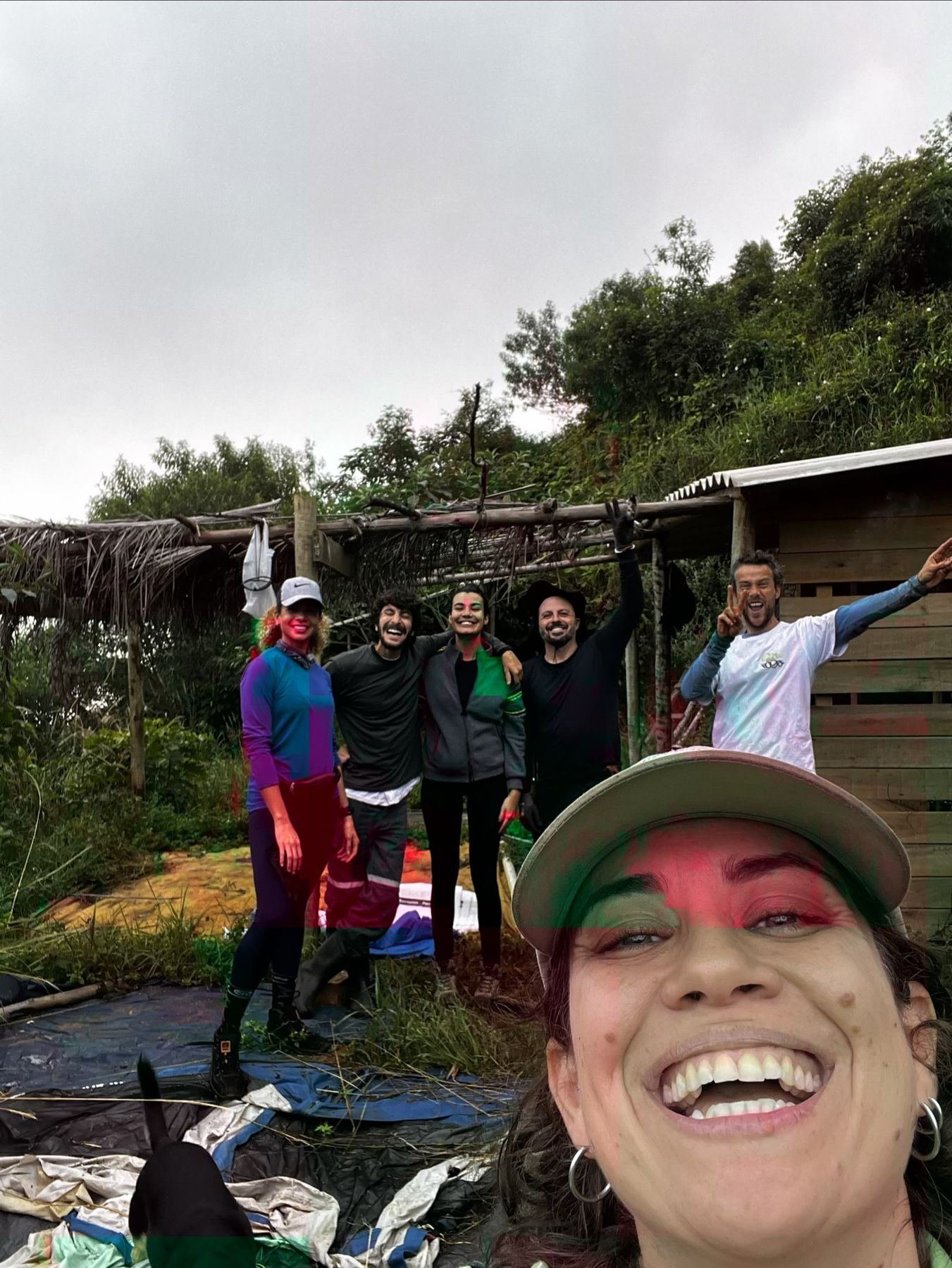 Grupo sorrindo em frente a uma construção de madeira no território