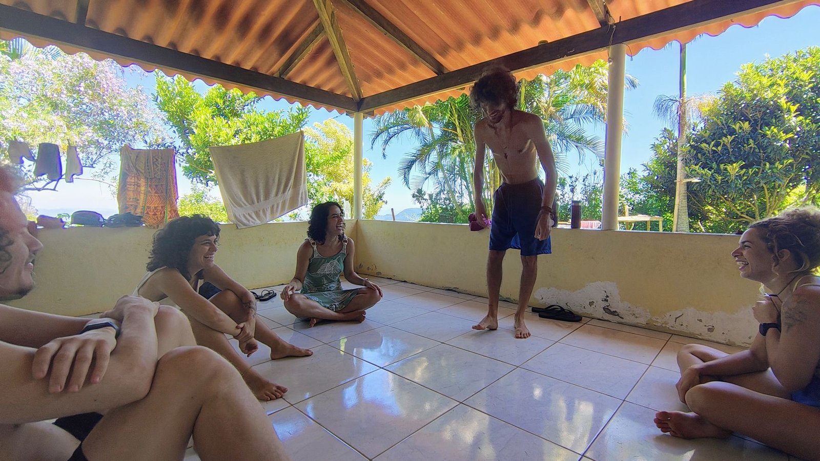 Roda de conversa na varanda, com pessoas sentadas no chão